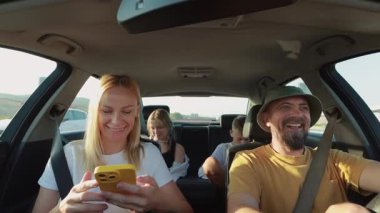Arkadaşlar araba sürerken eğleniyorlar.