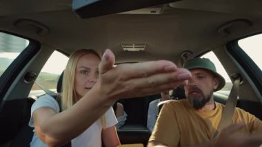 Genç bir kadın arabada oturuyor, kadın ve erkek arabada ve cep telefonu kullanıyor..