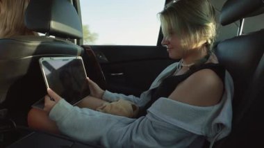 Arabada tableti olan bir kız.