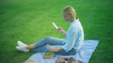 Parkta akıllı telefonu olan genç bir kız.