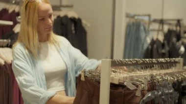 Kadın alışveriş için kıyafet seçiyor. Kadınlar alışveriş için kıyafet seçer.