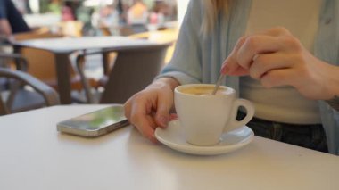 Kafede bir fincan kahvesi olan genç bir kadın.