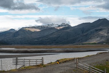 İzlanda 'nın arka planında İzlanda atları ve dağlar var. Yazın at ile İzlanda çayırları