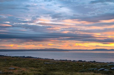 Ic 'deki Langanes yarımadasının kıyısında bulutlarla gün doğumu
