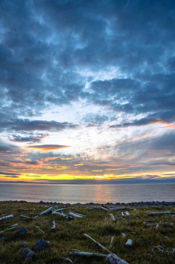 Ic 'deki Langanes yarımadasının kıyısında bulutlarla gün doğumu