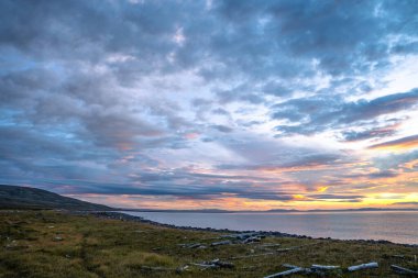 Ic 'deki Langanes yarımadasının kıyısında bulutlarla gün doğumu
