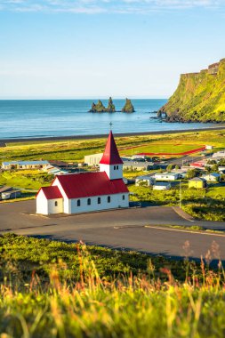 Bazalt yığınlarının manzarası Reynisdrangar, siyah kumsal, kilise...