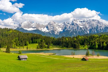 Geroldsee Gölü ahşap kulübeler ve karla kaplı Ka ile çevrili.