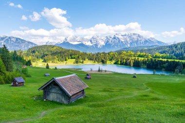 Geroldsee lake, surrounded by idyllic wooden huts and the snow-a clipart