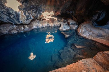İzlanda 'nın Mvatn bölgesindeki Grjtagj mağarası derinlikleri içinde mavi suları vurur.
