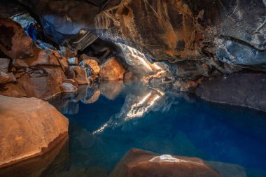 İzlanda 'nın Mvatn bölgesindeki Grjtagj mağarası derinlikleri içinde mavi suları vurur.