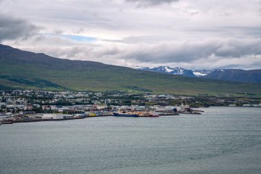 Kuzey İzlanda 'daki Akureyri şehrinin panoramik manzarası. Arkasında karla kaplı dağlar var.