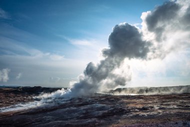 Reykjanesviti Lighthouse emerges from the thick geothermal steam of Gunnuhver a striking scene in Icelands southwest clipart