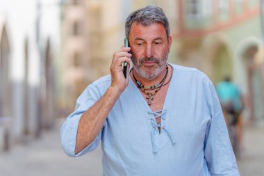 Şık giyinmiş tek başına bir gezgin eski Regensburg kasabasında yürüyor ve elinde telefonuyla güzelliğini keşfediyor.