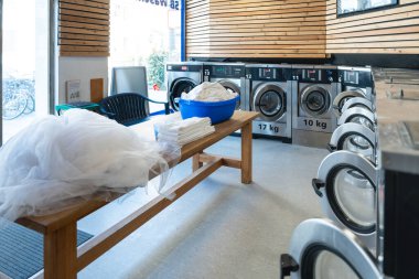 A spotless and airy laundromat designed for easy washing and drying, with a convenient layout clipart