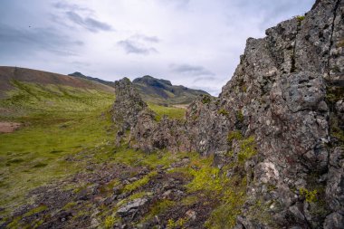 The untouched beauty of East Iceland unfolds with a flowing watercourse, rugged rock formations, and majestic mountains near Breiddalsvik clipart