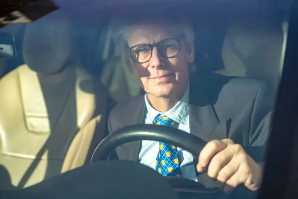 İş adamı işe gitmek için ya şirkette ya da girişimci olarak araba kullanıyor. E-arabadaki adam ve günlük araç, ulaşım, trafik ve güzergah