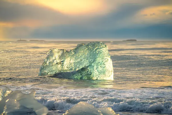 Güneşin doğuşuyla birlikte Jkulsrln yakınlarındaki buzul plajındaki eriyen buzuldan bir buz kütlesinin yakınına İzlanda 'daki Vatnajkull Ulusal Parkı' na.