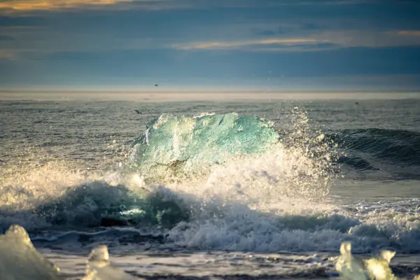 Güneşin doğuşuyla birlikte Jkulsrln yakınlarındaki buzul plajındaki eriyen buzuldan bir buz kütlesinin yakınına İzlanda 'daki Vatnajkull Ulusal Parkı' na.