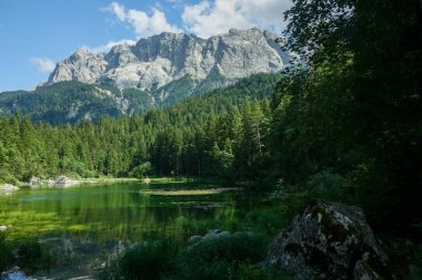 Yazın Eibsee 'de Zugspitze' deki kalabalıkla. Alman Alpleri, Bavyera, Almanya ve Avrupa 'da güneşli açık hava sahneleri
