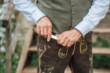 Bavyera deri pantolon giymiş bir adam ve geleneksel bir bıçak. Almanya, Bavyera 'da halk festivali.