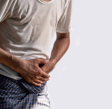 Üst karın ağrısı çeken Asyalı genç bir adam. Mide ağrısı, enterit, kolit, apandisit, hepatit, pankreas iltihabı, gıda zehirlenmesi, bağırsak sendromu vs. gibi hastalıklardan kaynaklanabilir..