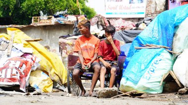 İki zavallı çocuk kameraya bakıyor.
