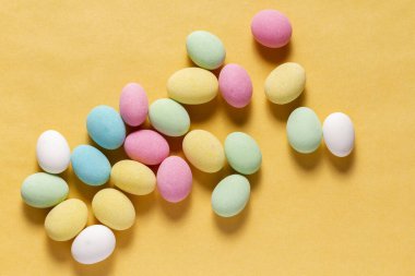 Pile of sweets on yellow background, top view