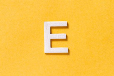 Letter E of the alphabet isolated on yellow background, top view