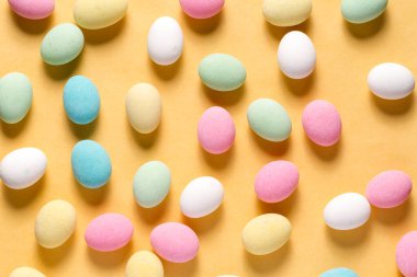 Pile of sweets on yellow background, top view
