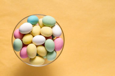 Pile of sweets on yellow background, top view