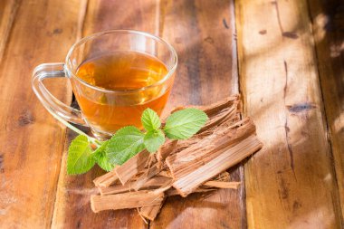 Cam fincanda kedi pençesi çayı, ahşap yüzeyde, kraliyet ailesi yok.