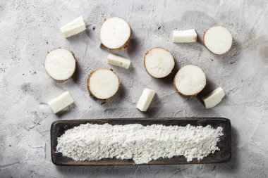 (Manihot esculenta) gri ve beyaz desenli arka plan üzerinde cassava kökü ve cassava unu yığını)