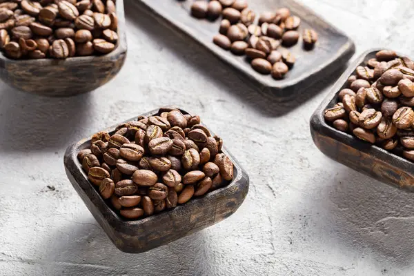 stock image Coffee beans roasted in cup on light background, coffee from Colombia