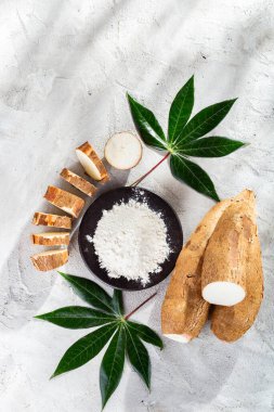 (Manihot esculenta) gri ve beyaz desenli arka plan üzerinde cassava kökü ve cassava unu yığını)