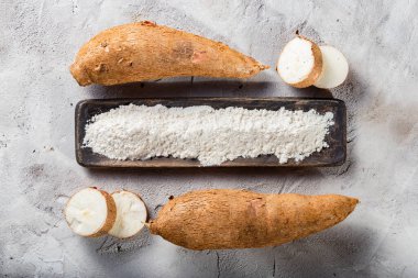 (Manihot esculenta) gri ve beyaz desenli arka plan üzerinde cassava kökü ve cassava unu yığını)