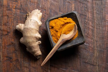 Zencefil kökü ve zerdeçal tozu kırsal ahşap üst görünümde.