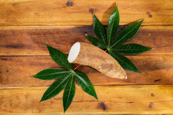 stock image cassava pile, yucca, on a background of rustic wood (Manihot esculenta)