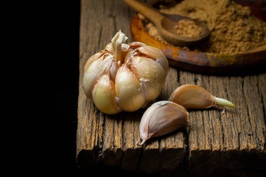 Tahtadaki sarımsak ampulü, koyu arkaplan, metin için boşluk