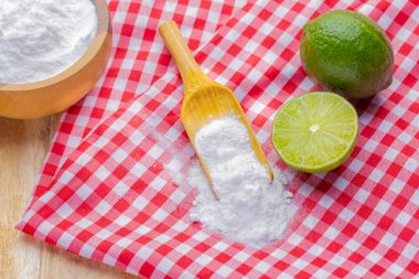 Tahta kasede kabartma tozu ve limon, masanın üstünde.