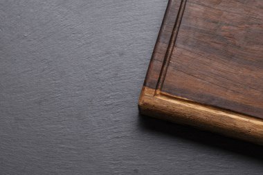 Kırsal ahşap kesme tahtasının biraz yuvarlak kenarlı yakın çekimi, arka planda dinleniyor..