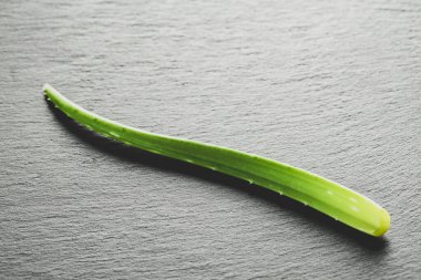 Bir aloe vera yaprağı arkaplanda, en üstteki görünümde görüntülenir