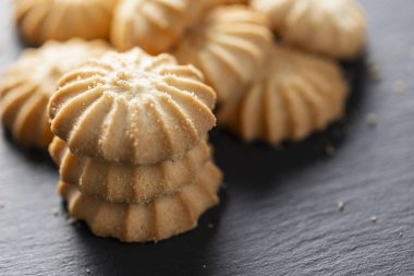 Görüntüde lezzetli kurabiyelerden oluşan bir yığın görüyorsunuz, arka planda yakın plan,