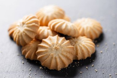 Görüntüde lezzetli kurabiyelerden oluşan bir yığın görüyorsunuz, arka planda yakın plan,