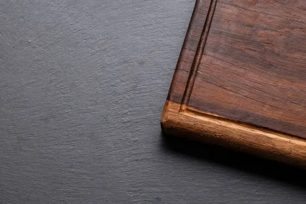 Kırsal ahşap kesme tahtasının biraz yuvarlak kenarlı yakın çekimi, arka planda dinleniyor..