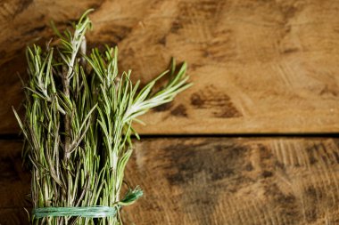 Resimde ahşap bir yüzey üzerinde biberiye yaprakları görebilirsiniz.