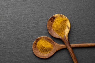 Tahta Kaşıklar Üzerine Renkli Baharatlar Curry, zerdeçal, ve Paprika Karanlık Sayfa Arkaplanda