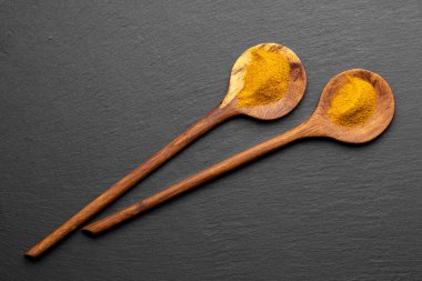 Tahta Kaşıklar Üzerine Renkli Baharatlar Curry, zerdeçal, ve Paprika Karanlık Sayfa Arkaplanda