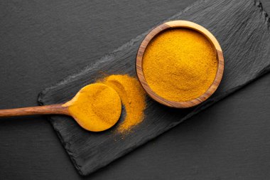 Tahta Kaşıklar Üzerine Renkli Baharatlar Curry, zerdeçal, ve Paprika Karanlık Sayfa Arkaplanda