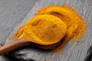 Tahta Kaşıklar Üzerine Renkli Baharatlar Curry, zerdeçal, ve Paprika Karanlık Sayfa Arkaplanda